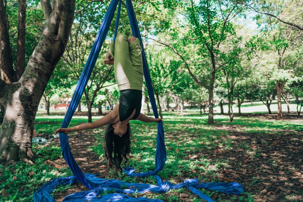 a woman is doing a handstand in the park